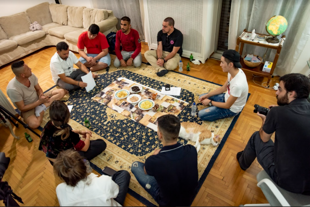 Neun Menschen sitzen im Kreis und diskutieren über einen Text